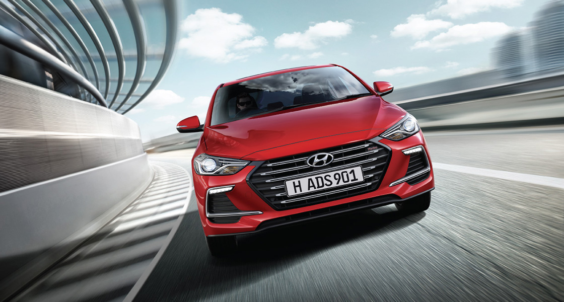 Front view of red Elantra Sport driving on the road